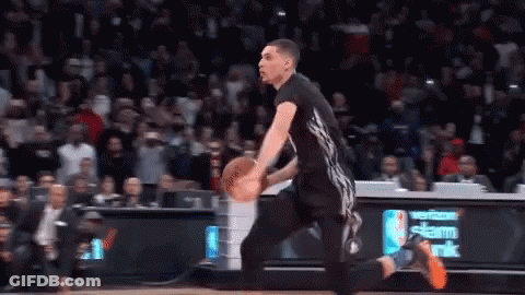 A Basketball Player Is Dribbling A Ball On A Court In Front Of A Verizon Sign . GIF