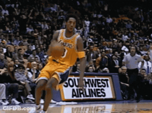 A Basketball Player Is Dribbling A Basketball In Front Of A Southwest Airlines Sign GIF