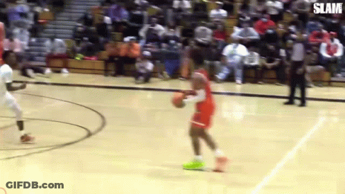 A Basketball Player Is Dribbling A Basketball On A Court While Another Player Tries To Stop Him . GIF