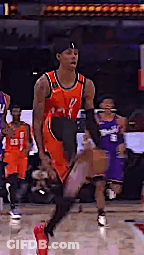 A Basketball Player Is Dribbling A Basketball On A Court While Other Players Watch . GIF