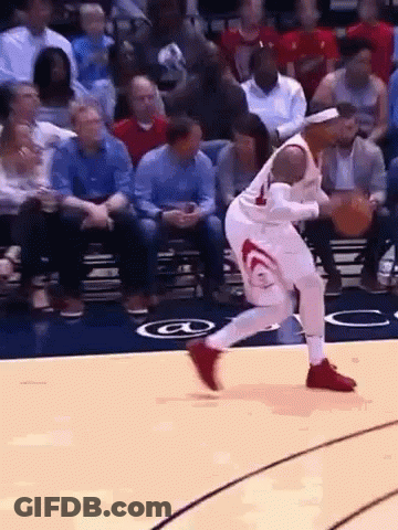 A Basketball Player Is Dribbling A Basketball On A Court With A Crowd Watching . GIF