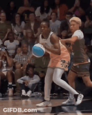 A Basketball Player Is Dribbling A Basketball While Another Player Tries To Stop Him . GIF