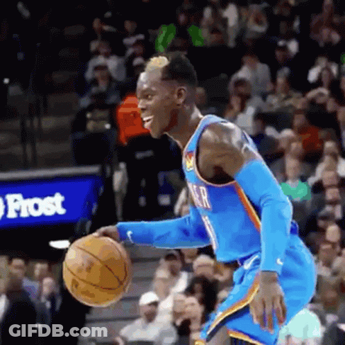 A Basketball Player Is Dribbling The Ball During A Game . GIF