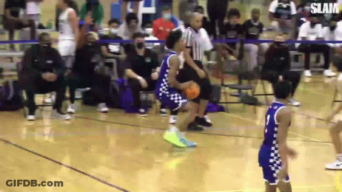 A Basketball Player Is Dribbling The Ball On A Court While Another Player Tries To Block Him . GIF