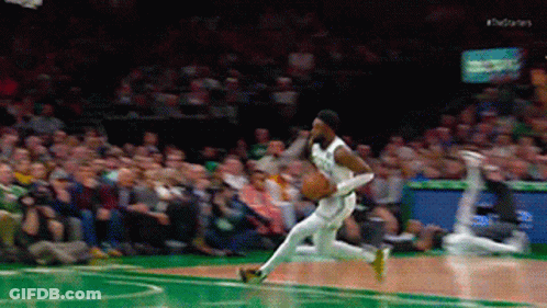 A Basketball Player Is Dribbling The Ball On A Court With A Crowd Watching GIF