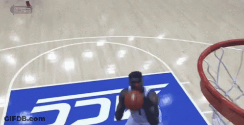 A Basketball Player Is Dunking A Ball On A Court With A Sign That Says Ucsd GIF