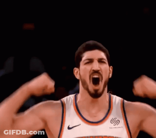 A Basketball Player Is Flexing His Muscles While Wearing A New York Knicks Jersey . GIF