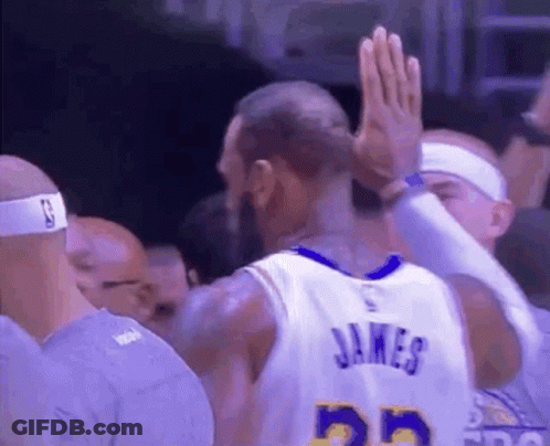 A Basketball Player Is Giving A High Five To His Teammate . GIF