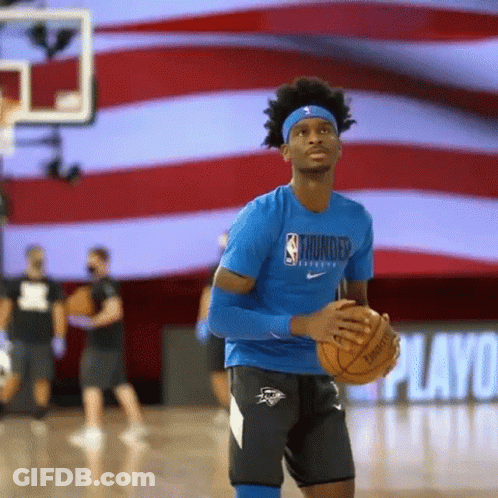 A Basketball Player Is Holding A Basketball On A Basketball Court . GIF