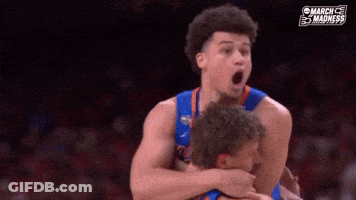 A Basketball Player Is Hugging Another Player With His Mouth Open During A Game . GIF