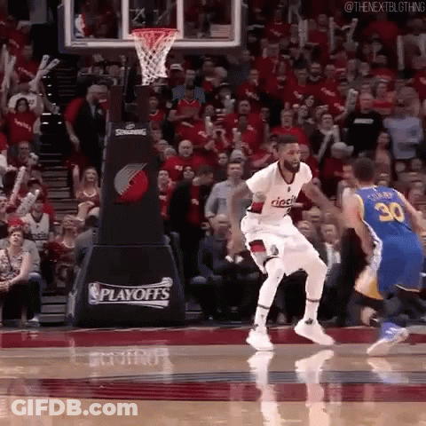 A Basketball Player Is Jumping In The Air In Front Of A Crowd During A Playoff Game . GIF