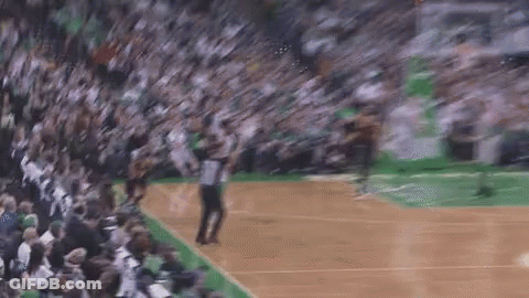 A Basketball Player Is Jumping In The Air In Front Of A Crowd Of People On A Court . GIF