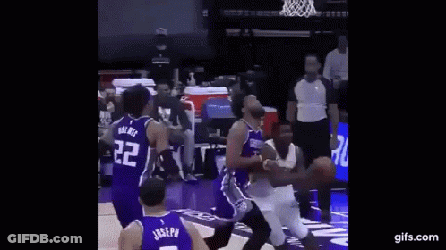 A Basketball Player Is Jumping In The Air To Dunk The Ball During A Basketball Game . GIF
