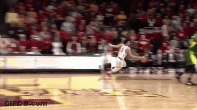 A Basketball Player Is Jumping In The Air While Dribbling The Ball GIF