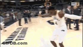 A Basketball Player Is Jumping In The Air While Holding A Basketball In Front Of A Banner That Says Bankers Hill Fieldho GIF