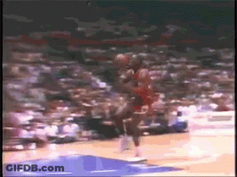 A Basketball Player Is Jumping In The Air While Holding A Basketball In His Hand . GIF