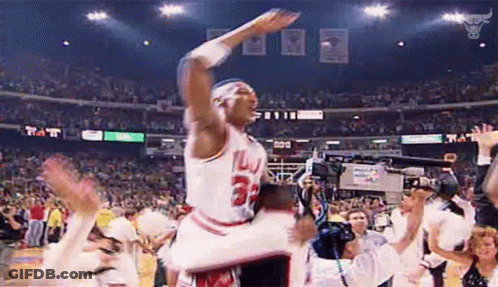 A Basketball Player Is Jumping In The Air While Holding A Trophy . GIF