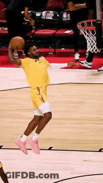 A Basketball Player Is Jumping In The Air While Holding The Ball GIF
