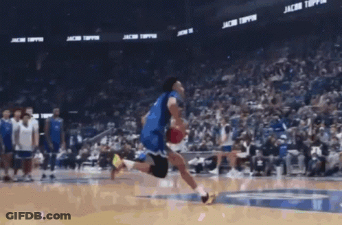 A Basketball Player Is Jumping In The Air With A Ball In Front Of A Banner That Says Jacob Toppin GIF