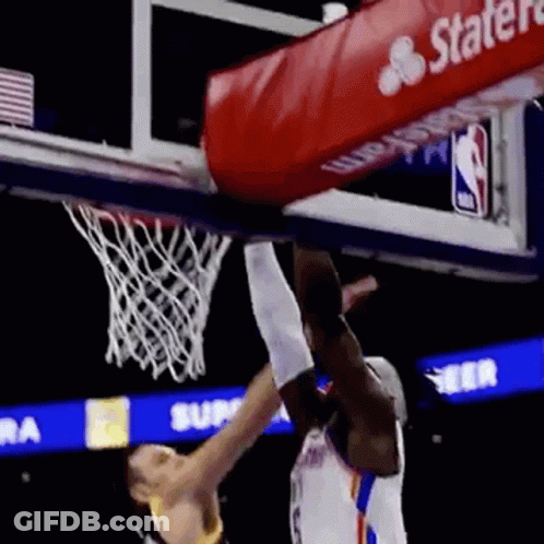 A Basketball Player Is Jumping Over Another Player Who Is Trying To Dunk The Ball . GIF