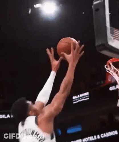 A Basketball Player Is Jumping To Catch A Basketball In The Air GIF