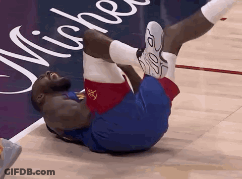 A Basketball Player Is Laying On His Back On The Court GIF