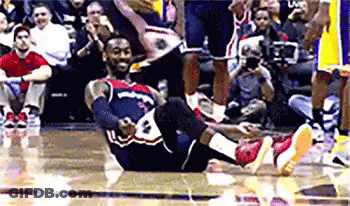 A Basketball Player Is Laying On His Back On The Floor During A Game GIF