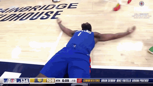 A Basketball Player Is Laying On The Floor In Front Of A Sign That Says Cambridge Lighthouse GIF
