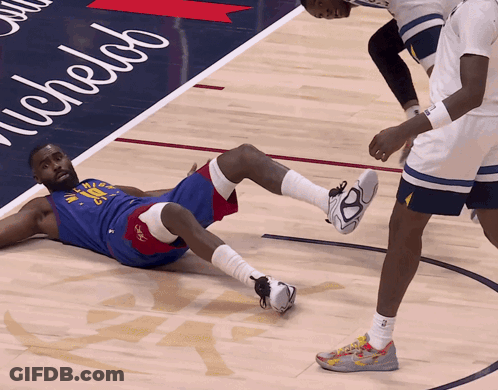 A Basketball Player Is Laying On The Floor With A Michelab Sign In The Background GIF
