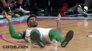 A Basketball Player Is Laying On The Floor With His Legs Crossed . GIF