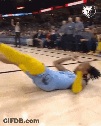 A Basketball Player Is Laying On The Floor With His Legs Up GIF