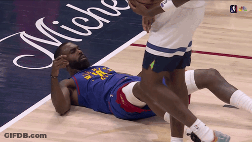 A Basketball Player Is Laying On The Floor With Micheal Written On The Floor Behind Him GIF
