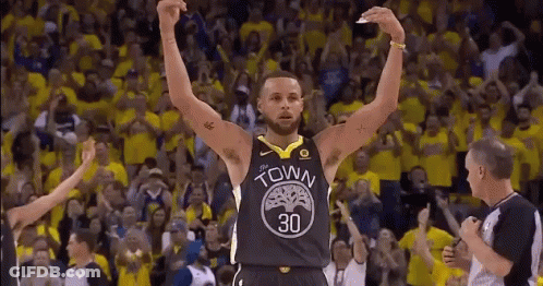 A Basketball Player Is Raising His Arms In The Air In Front Of A Crowd Of Fans . GIF