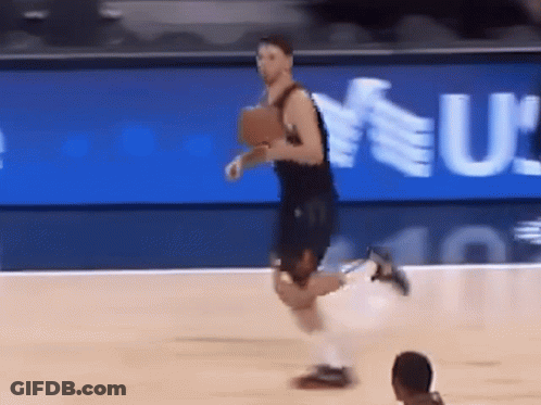 A Basketball Player Is Running On The Court In Front Of A Sign That Says U GIF