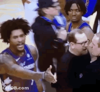 A Basketball Player Is Shaking Hands With A Referee While Standing Next To A Group Of Men . GIF
