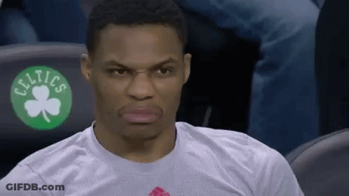 A Basketball Player Is Sitting In The Stands Wearing A White Shirt With A Green Shamrock On It . GIF