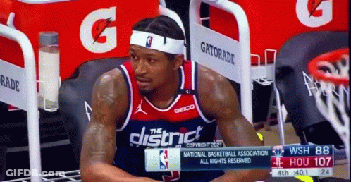 A Basketball Player Is Sitting On The Bench During A Game . GIF