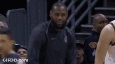 A Basketball Player Is Sitting On The Bench During A Game While Another Player Looks On . GIF