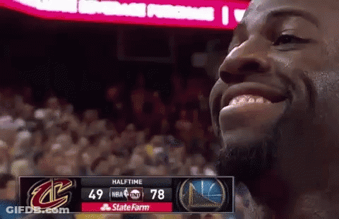 A Basketball Player Is Smiling In Front Of A Scoreboard That Says Halftime On It GIF