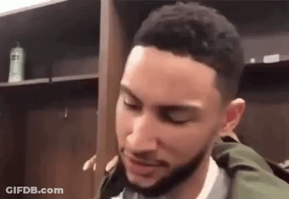 A Basketball Player Is Standing In A Locker Room With His Eyes Closed . GIF