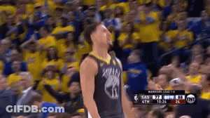 A Basketball Player Is Standing In Front Of A Crowd Of People . GIF