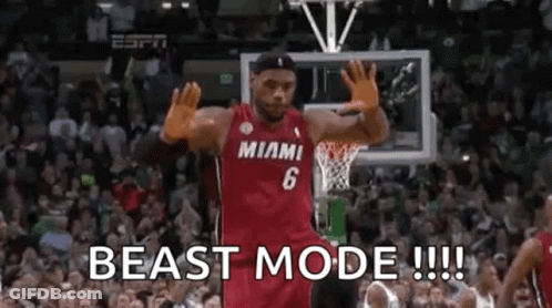 A Basketball Player Is Standing In Front Of A Crowd On A Basketball Court With His Hands In The Air . GIF