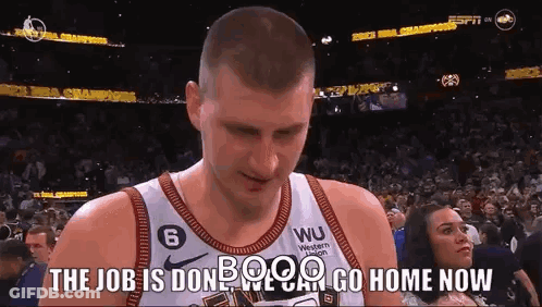 A Basketball Player Is Standing In Front Of A Crowd With A Woman Watching . GIF