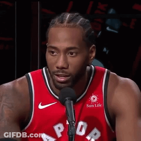 A Basketball Player Is Standing In Front Of A Microphone And Talking Into It . GIF