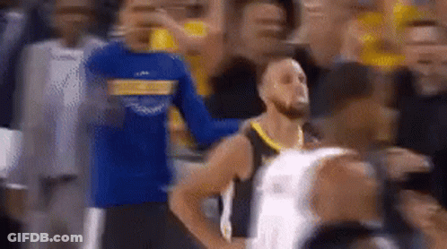 A Basketball Player Is Standing In The Middle Of A Crowd . GIF