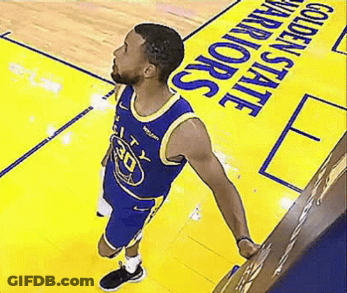A Basketball Player Is Standing On A Basketball Court In Front Of A Golden State Warriors Sign . GIF