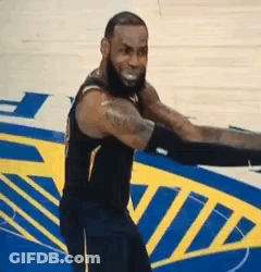 A Basketball Player Is Standing On A Basketball Court With His Arms Outstretched And Smiling . GIF