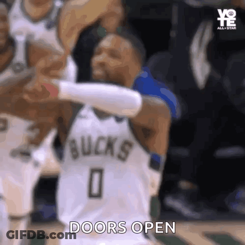 A Basketball Player Is Standing On A Court With His Arms Outstretched And The Words `` Doors Open '' Written On His Shir GIF