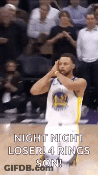 A Basketball Player Is Standing On A Court With His Hands On His Head And A Crowd Behind Him . GIF