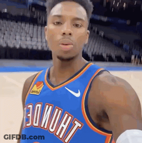 A Basketball Player Is Taking A Selfie On A Basketball Court While Wearing A Blue Jersey . GIF